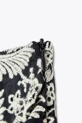 Short de tiro alto con detalle de nudo delantero y bordados florales perforados.