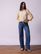 Blusa estampada de Zac & Rachel con cuello a la base, escote en V y botones. Tiene un bolsillo aplicado en la parte delantera, mangas largas regulables con presilla y botón, y terminación anudada opcional.