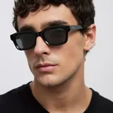 Lentes de sol con montura cuadrada de diseño angular y acabado brillante. Cuentan con lentes polarizadas de color negro y protección UV400.