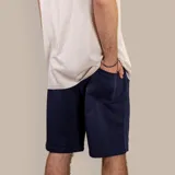 Bermuda deportiva azul marino de algodón, con cintura elástica ajustable con cordón, bolsillos laterales y bolsillo trasero.