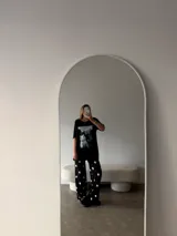 Remeron negro de corte oversize con estampa frontal de gatos. Confeccionado en algodón, presenta cuello redondo y mangas cortas.