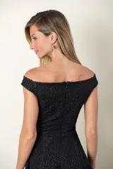 Vestido negro con textura en relieve, falda acampanada y escote con abertura.