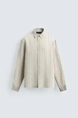 Camisa de corte regular confeccionada en tejido con mezcla de modal, con diseño de rayas verticales, cuello solapa, manga larga con puños abotonados y cierre frontal de botones.