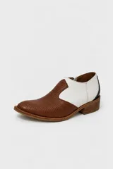 Zapatos de cuero bicolor, combinando blanco en la parte superior y marrón con textura símil reptil en la puntera, con cierre lateral mediante hebilla.