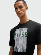 Remera de algodón negra con cuello redondo y manga corta. Presenta un estampado frontal con el logo de la marca en color verde sobre un diseño de franjas verticales con efecto de nubes.