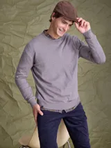 Sweater de cuello redondo y manga larga, confeccionado en una mezcla de algodón y cashmere. Presenta un diseño clásico de tejido de punto liso con puños y ruedo acanalados.