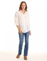 Camisa de algodón broderie color blanco, marca Liv Los Ángeles. Cuello con solapa, abertura central con botones y mangas ¾ amplias.