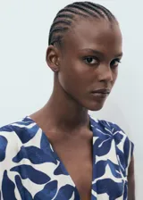 Vestido largo de corte evasé con estampado botánico en azul y blanco. Presenta cuello de pico, mangas cortas y un panel fruncido en la cintura con cordón ajustable.