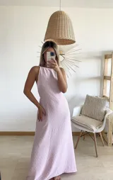 Vestido largo color rosa con textura plumetie, escote halter y espalda descubierta.