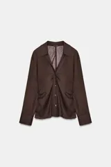 Camisa marrón oscuro de manga larga con cuello solapa y escote pico. Presenta un tejido con textura sutilmente arrugada y drapeados fruncidos en los laterales frontales. Cierre frontal con botones dorados.