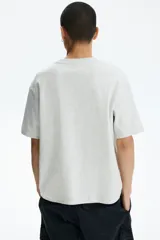 Remera de corte holgado confeccionada en punto interlock de algodón, con cuello redondo acanalado y hombros caídos.