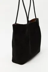 Cartera tipo shopper de gamuza color marrón, con diseño minimalista, formato amplio y asas largas para llevar al hombro.