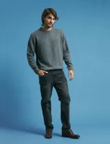 Pantalon denim de cinco bolsillos, corte recto y color negro, con botones y remaches metálicos en tono plata viejo.