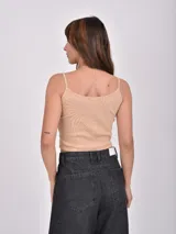 Musculosa ajustada color rosa claro, con ribetes rojos en el escote y los breteles. Presenta un bordado frontal con el texto "MORE AMOR" en rojo.