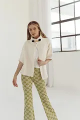 Pantalón acampanado con estampado abstracto en tonos verde y dorado.