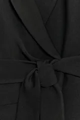 Blazer de cuello solapa y manga larga, con cierre frontal cruzado y cinturón del mismo tejido para anudar en la cintura. Presenta frunces en el delantero y abertura en la espalda.