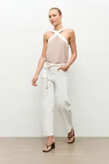 Jean barrel color blanco, de tiro alto y corte relajado con piernas curvas, estilo cropped y presillas en la cintura.