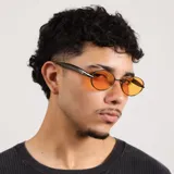 Lentes de sol con armazón metálico de diseño ovalado y cristales color naranja con protección UV400.