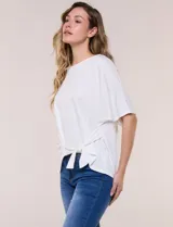 Remera blanca de manga corta, confeccionada en mezcla de modal, con diseño fluido y detalle de lazo ajustable en el lateral.