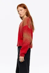 Cardigan corto de corte globo confeccionado en mezcla de alpaca, con botones frontales, escote caja y manga larga con forma. Presenta un diseño bicolor con bloques de color rojo y marrón.
