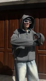 Campera con capucha y cierre frontal, color hueso con rayas horizontales finas en gris oscuro.