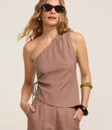 Blusa sastre de un solo hombro con tirante ancho, bajo asimétrico y detalle de tiras ajustables con regulador en el lateral.