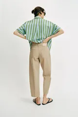 Pantalón de tiro medio con diseño barrel, pernera holgada que se estrecha hacia el tobillo y detalle de raya planchada en el frente y la espalda. Cuenta con cinco bolsillos y cierre frontal con cremallera y botón.
