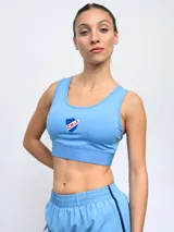 Top deportivo de Umbro para mujer, color azul marino, con el escudo del Club Nacional de Football en el centro y banda elástica inferior con la marca estampada.