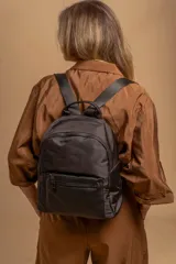 Mochila urbana de diseño combinado, confeccionada en tela resistente con bolsillo frontal y detalles en cuero sintético. Cuenta con compartimento principal con cierre y correas ajustables.