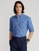 Camisa celeste de corte clásico, confeccionada en tela Oxford de algodón, con cuello button-down, manga larga con puños abotonados y logo bordado en el pecho.