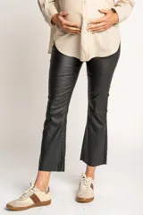 Pantalón negro de corte flare, tiro medio y efecto encerado.