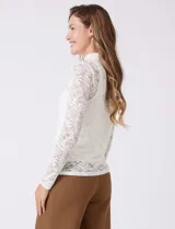 Blusa de encaje negro con cuello alto y mangas largas. Incluye musculosa interna a tono para mayor cobertura.