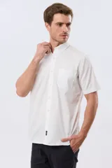 Camisa sport blanca de manga corta, con cuello abotonado, cierre frontal de botones y bolsillo ojal en el pecho.