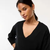 Sweater negro de punto fino con cuello en V y mangas largas.