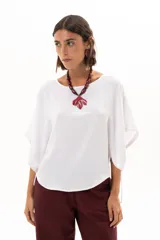 Blusa blanca de corte holgado y diseño minimalista, con mangas cortas tipo murciélago que presentan un detalle de fruncido lateral con cordón ajustable.