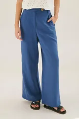Pantalón de lino azul de corte recto y amplio, con cintura elastizada, cierre de cremallera y botón. Presenta detalles de pespunte blanco en los bordes de los bolsillos.