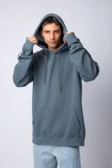 Buzo canguro oversize de tela friza, color negro, con capucha, cordones ajustables con logo y bolsillo frontal tipo canguro.