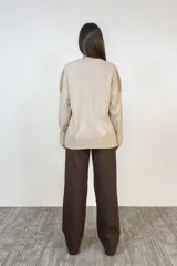 Pantalón de corte recto y tiro alto en color marrón, con bolsillos laterales y cierre frontal con botones.