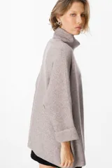 Sweater verde militar de viscosa, poliéster y poliamida, con cuello alto y mangas 3/4 con puños doblados.