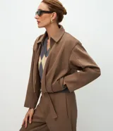 Campera corta de algodón con felpa, diseño tipo baloné con cuello clásico y cierre frontal de cremallera metálica. Presenta un corte holgado y estructura uniforme.