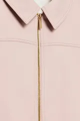Chaqueta rosa de cuello solapa y manga larga, con cierre frontal y detalles de cremallera metálica.