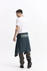 Camisa de popelina a cuadros, color celeste y blanco, de manga larga y corte holgado. Presenta un bolsillo frontal y cartera abotonada.