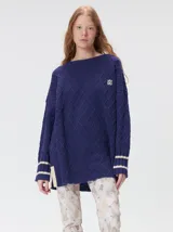 Sweater de cuello redondo con diseño de tejido en relieve de rombos, manga larga y calce holgado. Presenta logo bordado en el pecho y aberturas laterales en el ruedo.