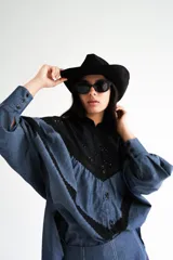 Blusa con cuello mao y mangas globo, confeccionada en algodón. La parte superior es de rayas azules y blancas, y la parte inferior es blanca con detalles de encaje.