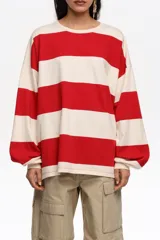 Remera manga larga oversize con diseño de rayas horizontales anchas rojas y blancas, cuello redondo y calce holgado.