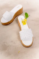 Sandalia con plataforma de corcho confeccionada en cuero vacuno, con capellada tejida.