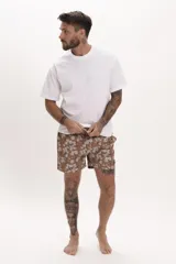 Short de baño marrón con estampado floral en tonos blancos y azules, de corte clásico y cintura elástica con cordón ajustable.