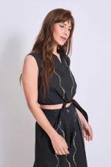 Camisa sin mangas color negro con cuello clásico, abotonada al frente y detalle de strass en el frente.