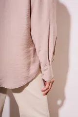 Blusa color visón con escote en V profundo y lazos ajustables en el frente, mangas largas y corte holgado.