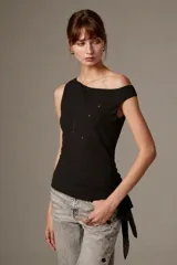Blusa de poliéster negra, sin mangas, con cuello asimétrico, detalles bordados y sutiles lentejuelas.